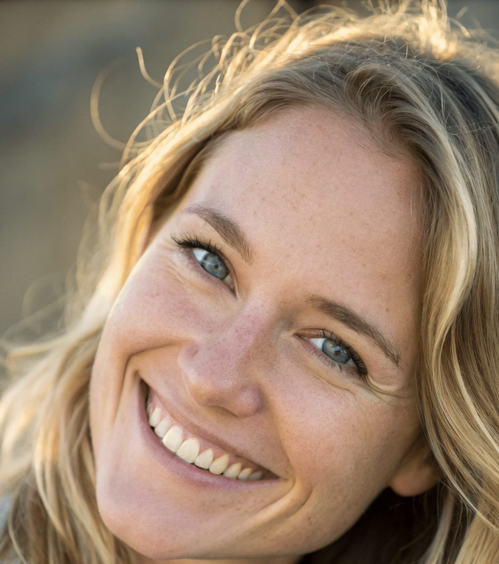 About me 1 about me Smiling blonde woman with blue eyes, wearing a casual jacket, looking directly at the camera in natural light.