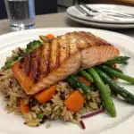 A colorful plate of gluten-free food including vegetables, grilled chicken, and quinoa